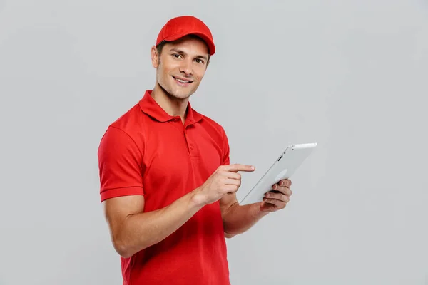 Jovem Homem Entrega Uniforme Usando Apontando Dedo Para Tablet Computador — Fotografia de Stock