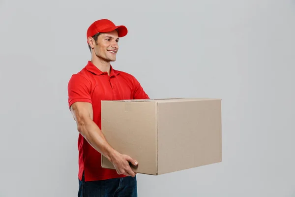 Joven Repartidor Sombrero Sonriendo Mientras Posa Con Caja Cartón Aislada — Foto de Stock