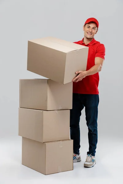 Jovem Entregador Chapéu Sorrindo Enquanto Posava Com Caixas Papelão Isoladas — Fotografia de Stock