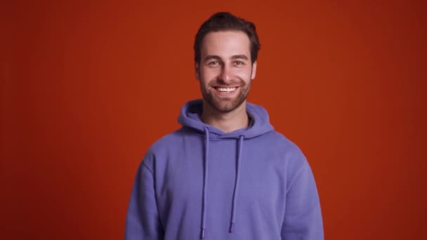 Hombre Sonriente Sudadera Con Capucha Púrpura Mostrando Gesto Saludo Estudio — Vídeos de Stock