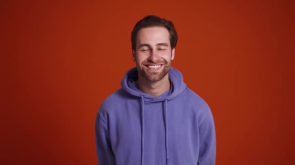 Hombre Sonriente Sudadera Con Capucha Púrpura Riendo Estudio Naranja — Vídeos de Stock