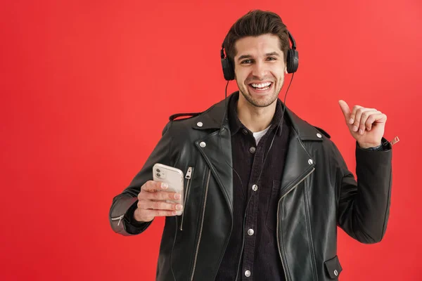 Young Unshaven Man Dancing While Using Cellphone Headphones Isolated Red — Stock Photo, Image