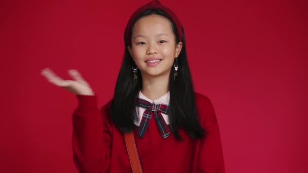 Positive Little Asian Girl Waving Her Hand Camera Red Studio — ストック動画