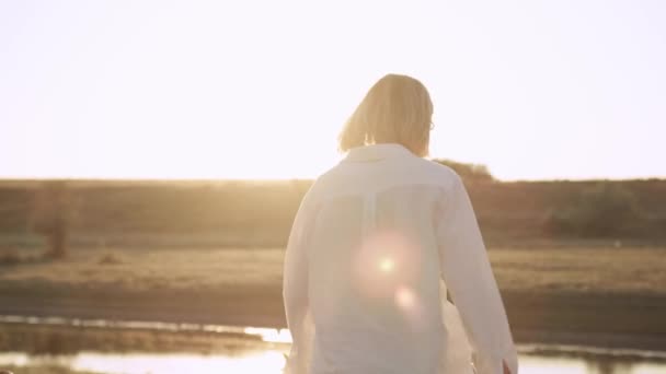 Rückansicht Einer Frau Die Bei Sonnenuntergang Zum Fluss Geht — Stockvideo