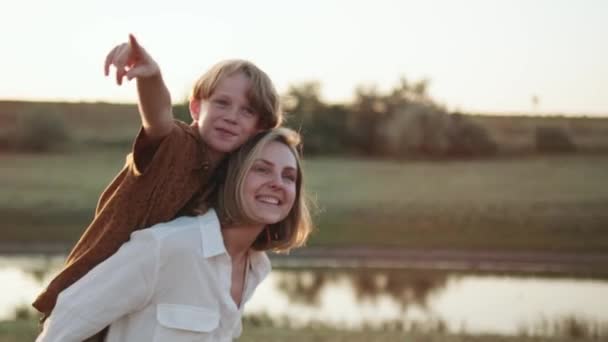 Pozitif Anne Oğlunu Sırtında Taşır Parmağıyla Nehri Gösterir — Stok video