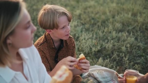 Leende Liten Kille Äter Croissant Picknick Tid Med Sin Familj — Stockvideo