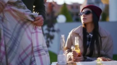 Adam piknikte donmuş bir kadını battaniyeyle örtüyor.