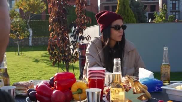 戴着眼镜微笑的女人和她的朋友聊天 在野餐时喝啤酒 — 图库视频影像