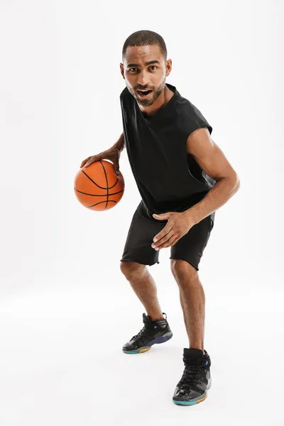 年轻的黑人运动员一边打篮球 一边在白种人的背景下打篮球 — 图库照片