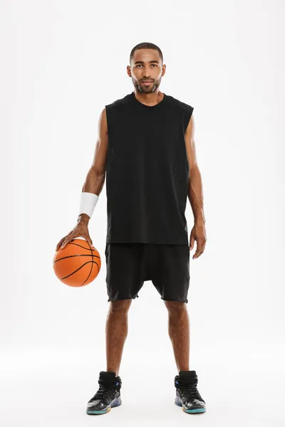 年轻的黑人运动员拿着白色背景的篮球摆姿势 看着镜头 — 图库照片
