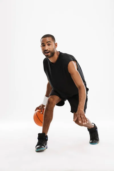 年轻的黑人运动员一边打篮球 一边在白种人的背景下打篮球 — 图库照片