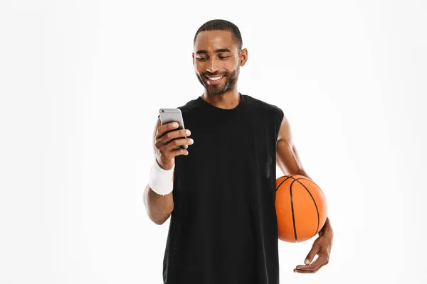 Счастливый Африканский Молодой Баскетболист Стоит Разговаривая Мобильному Телефону Изолированы Белом — стоковое фото