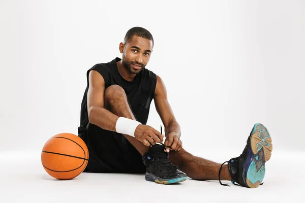 Black Sportsman Tying His Shoelaces While Sitting Floor Basketball Isolated — Stock Photo, Image