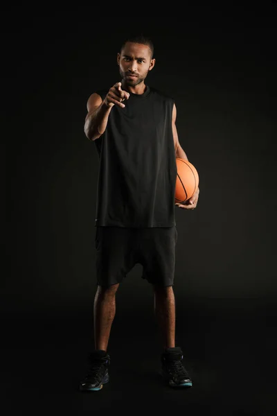 Pemuda Olahragawan Menunjuk Jari Kamera Sementara Berpose Dengan Basket Terisolasi — Stok Foto