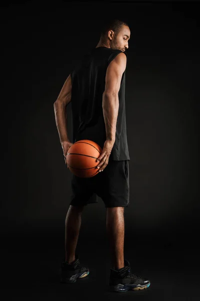 Jovem Desportista Olhando Para Baixo Enquanto Posando Com Basquete Isolado — Fotografia de Stock