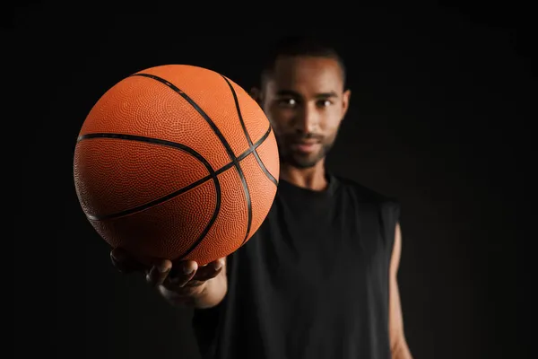 Joven Deportista Mirando Alcanzando Baloncesto Cámara Aislada Sobre Fondo Negro —  Fotos de Stock