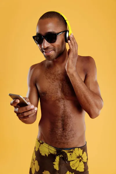 Mladý Usmívající Pohledný Černoch Poslouchající Hudbu Sluchátkách Mobilním Telefonu Chlápek — Stock fotografie