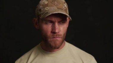 Siyahi stüdyodaki dalgın askerin yakından görünüşü.