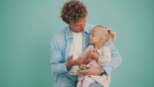 Yakışıklı Bir Baba Kızıyla Konuşurken Elinde Tahta Küplerle Mavi Stüdyoda — Stok video
