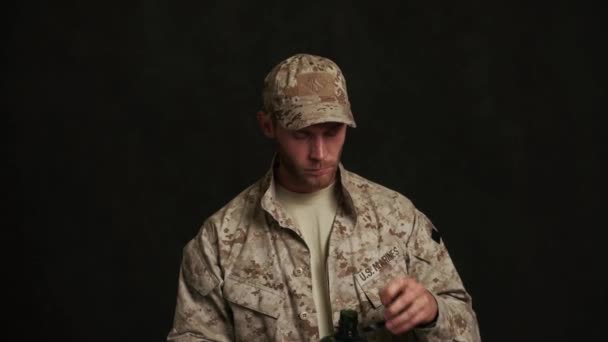 Σοβαρός Στρατιωτικός Που Πίνει Νερό Από Ένα Φλασκί Μαύρο Στούντιο — Αρχείο Βίντεο