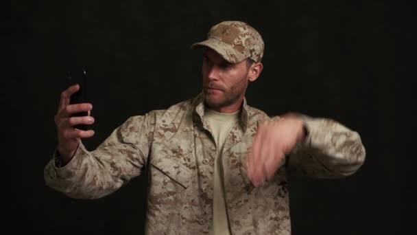 Serieuze Militaire Man Aan Het Praten Videogesprek Telefoon Zwarte Studio — Stockvideo