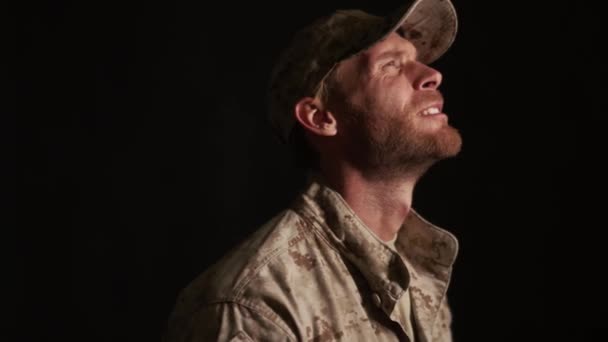 在黑漆漆的演播室里 一个悲伤的军人摘下帽子哭泣的侧面景象 — 图库视频影像