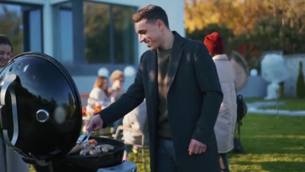 Glimlachende Knappe Man Bereiden Gegrilde Worsten Picknick — Stockvideo