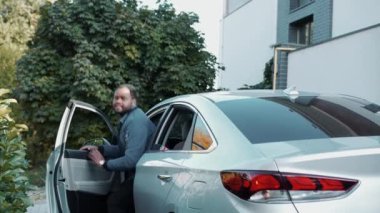 Gülümseyen Afrikalı aile arabadan iniyor.