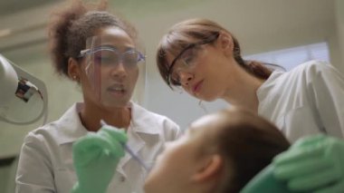 Mutlu Afrikalı dişçi kızın boşluğunda stajyerine bir şey gösteriyor.