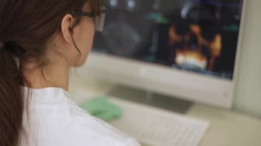 Monitördeki çene resmine bakan bir doktorun arka planı