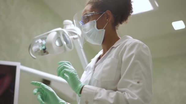 Dentista Africano Sorrindo Explicando Algo Para Sua Paciente — Vídeo de Stock