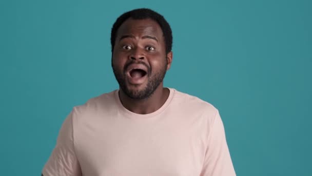 Hombre Africano Sonriente Con Camiseta Saludando Cámara Estudio Azul — Vídeo de stock