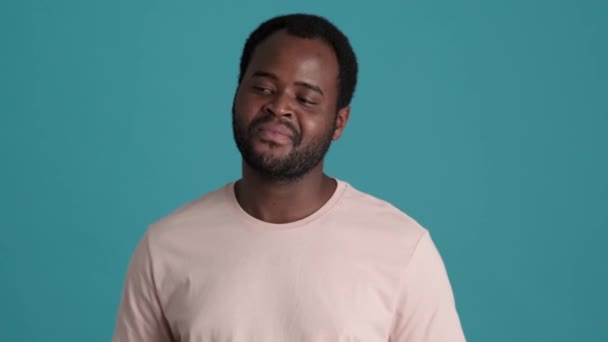 Verlegen Afrikaanse Man Draagt Shirt Naar Beneden Kijkend Blauwe Studio — Stockvideo