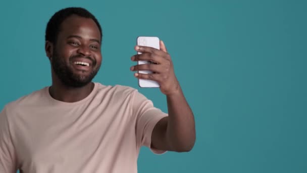 Χαρούμενος Αφρικανός Που Φοράει Μπλουζάκι Και Μιλάει Βιντεοκλήση Στο Τηλέφωνο — Αρχείο Βίντεο