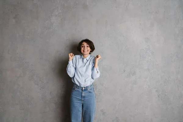 Joven Morena Haciendo Gesto Ganador Sonriendo Aislada Sobre Pared Gris —  Fotos de Stock