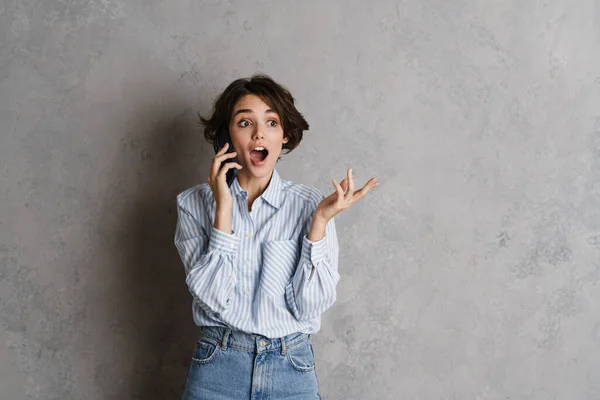 Mujer Morena Joven Expresando Sorpresa Mientras Habla Teléfono Celular Aislado — Foto de Stock