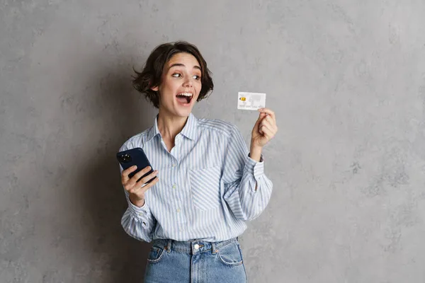 Junge Brünette Frau Posiert Mit Kreditkarte Und Handy Isoliert Über — Stockfoto