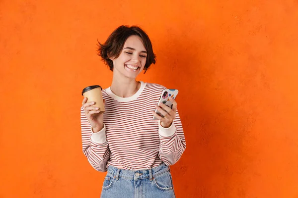 Young Brunette Woman Drinking Coffee While Using Mobile Phone Isolated — Stock Photo, Image