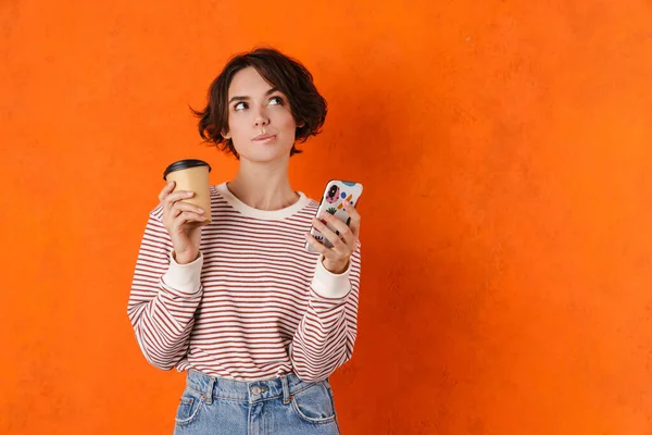 Joven Morena Bebiendo Café Mientras Usa Teléfono Móvil Aislado Sobre —  Fotos de Stock