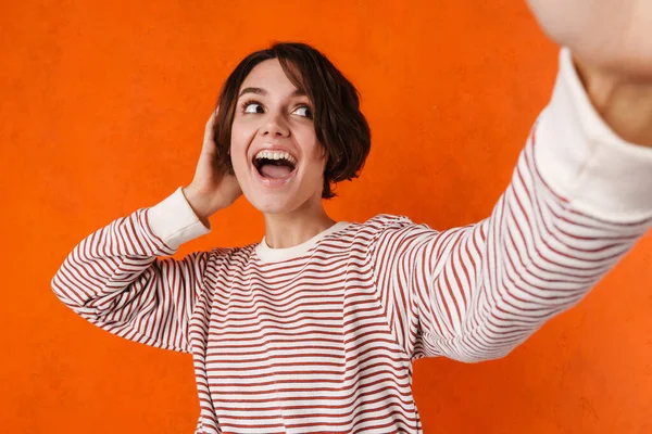 Young Brunette Woman Laughing While Taking Selfie Photo Isolated Orange — Stock Photo, Image