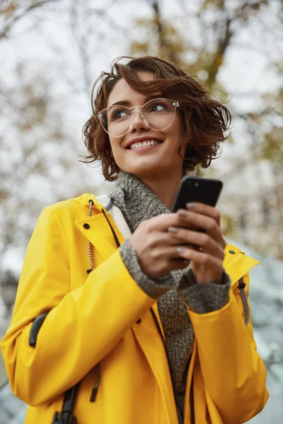 Chica Joven Impermeable Amarillo Con Smartphone Mano Caminando Por Ciudad —  Fotos de Stock