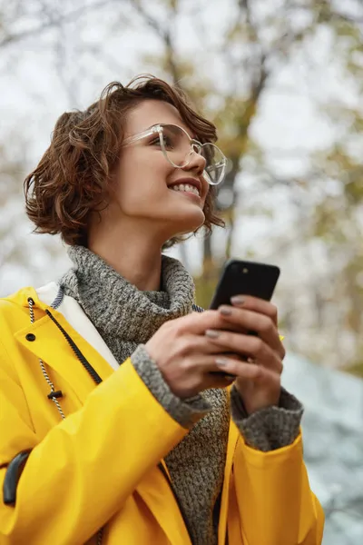 Chica Joven Impermeable Amarillo Con Smartphone Mano Caminando Por Ciudad —  Fotos de Stock