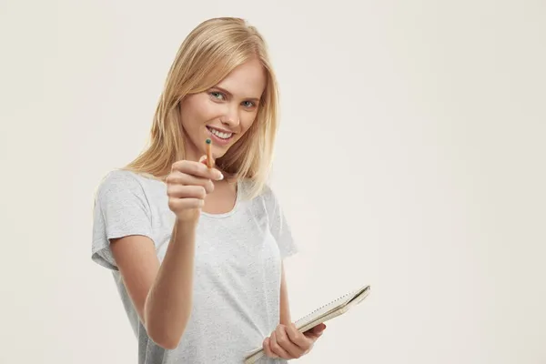 Junge Lächelnde Europäerin Hält Notizbuch Der Hand Und Zeigt Mit — Stockfoto