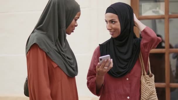 Zwei Fröhliche Muslimische Frauen Unterhalten Sich Beim Telefonieren Freien — Stockvideo