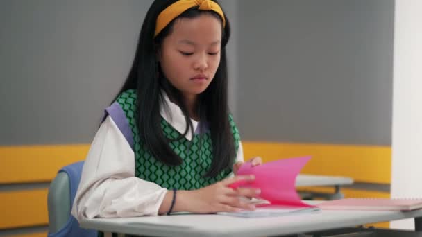在学校的练习本上写东西的亚洲女孩 — 图库视频影像