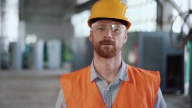 Üniformalı adam kameraya bakıyor.