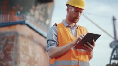 Dışarıdaki tablette yazan üniformalı kendine güvenen bir gemi yapımcısı.