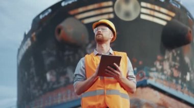 Dışarıdaki tablette yazan üniformalı bir gemi yapımcısı.