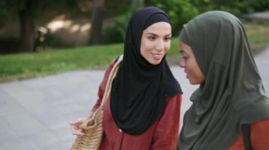 İki pozitif Müslüman kadın dışarıda yürürken konuşuyor.