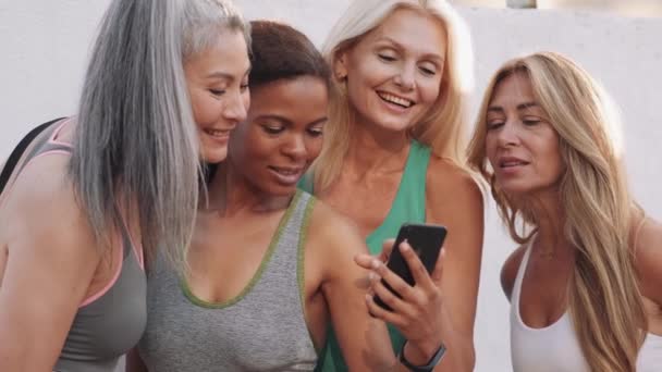 Lächelnde Erwachsene Multinationale Frauen Die Draußen Auf Das Telefon Schauen — Stockvideo